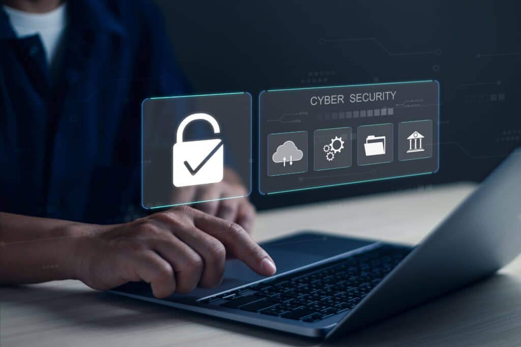A person uses a laptop with holographic icons above it, including a lock, cloud, settings, and bank symbol, representing the concept of cyber liability insurance.