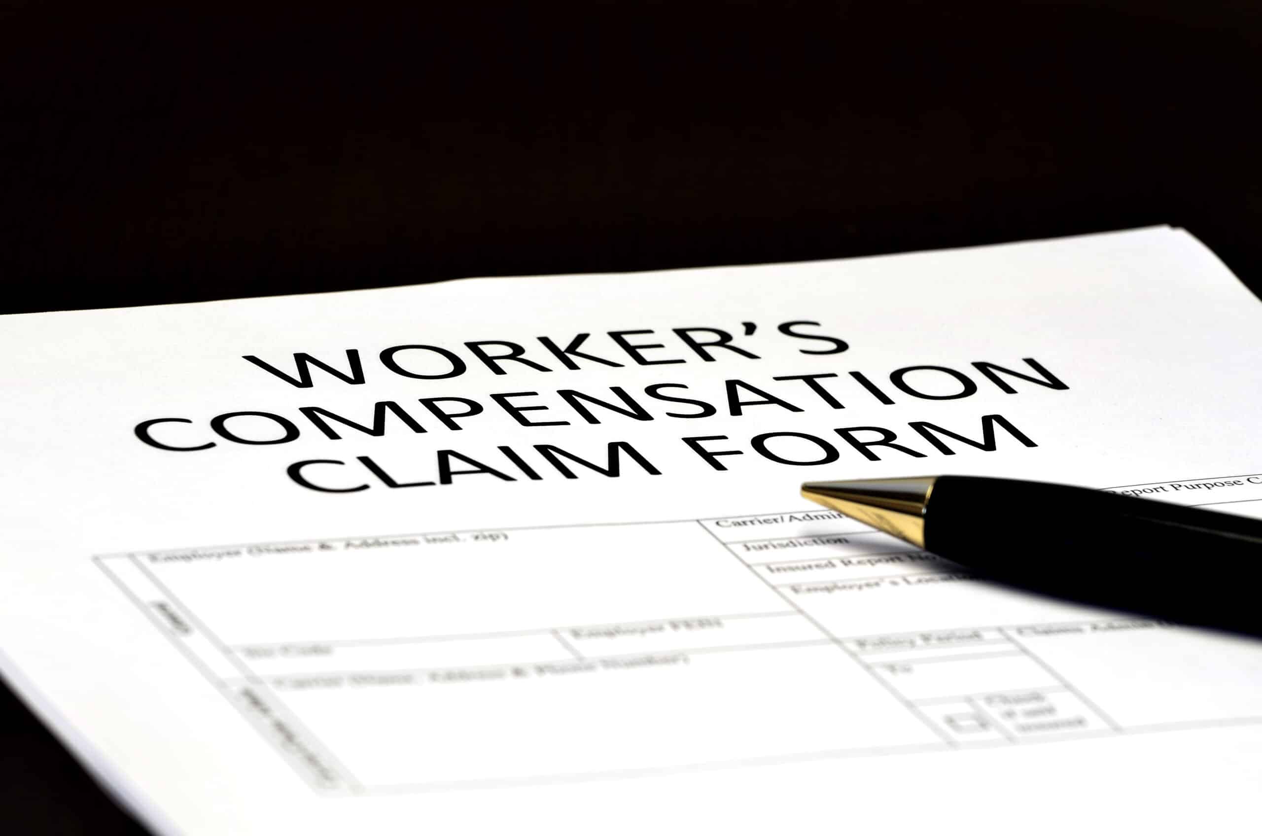 A pen rests on a worker's compensation claim form, offering essential insights into the detailed sections for employee details—an important tool for small business owners navigating workers' compensation insurance.