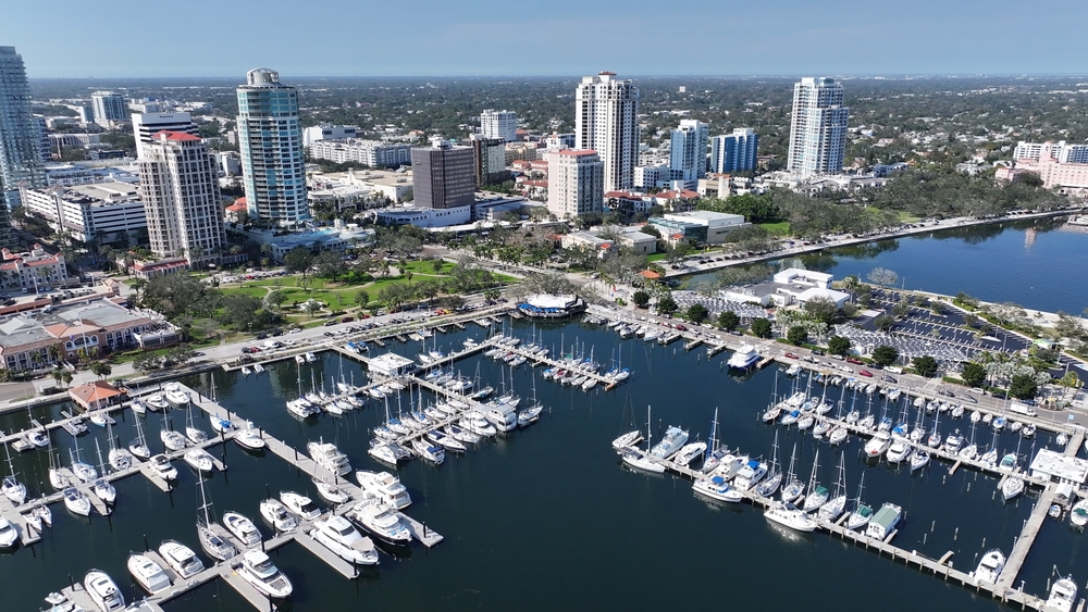Aerial view of a marina filled with boats, surrounded by high-rise buildings and green spaces in a city near a body of water—reflecting the thriving business environment where Business Owners Insurance Florida plays a vital role in protecting local enterprises.